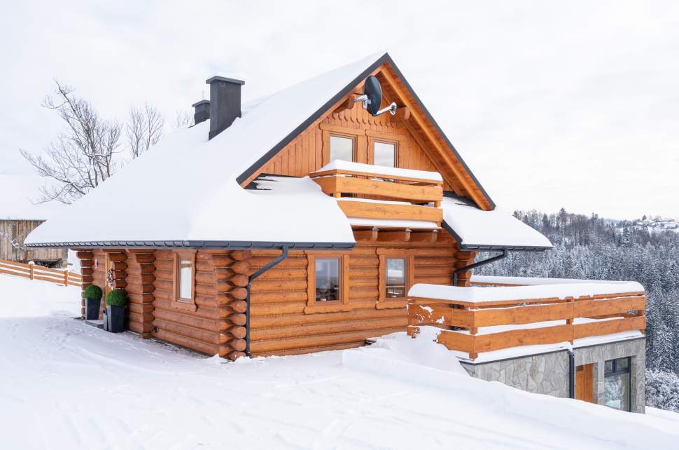 Drewniany dom z tarasem w zimowej scenerii
