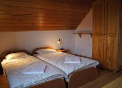 Dwa łóżka, drewniana szafa