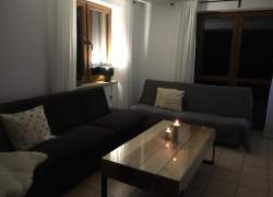 Salon - szare kanapy, stolik ze świecami, okno balkonowe