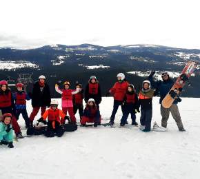 Zdjęcie grupowe na terenie ośrodka narciarskiego, w tle góry