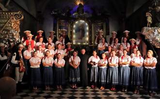 Zespół "Istebna", w środku ksiądz dziekan Tadeusz Pietrzyk, z prawej prowadząca koncert Aneta Legierska, w tle obraz Dobrego Pasterza