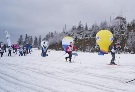 Grupa najmłodszych biegaczy na trasie, w tle zimowy krajobraz i balon z Lotto