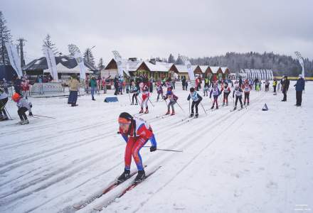 Dziewczęta z kategorii III – IV na trasie biegu, w tle zabudowania zaplecza organizacyjnego, oraz chorągiewki  promocyjne