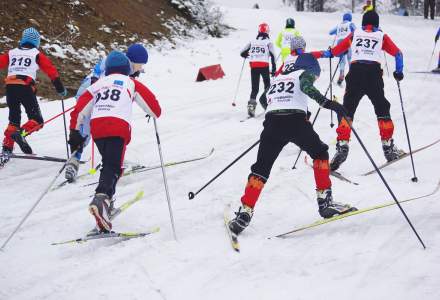 Chłopcy z kategorii wiekowej III-IV na trasie biegu narciarskiego widziani od tyłu na podbiegu; na pierwszym planie Jojko Antoni i Niemczyk Filip, widocznych ośmiu biegaczy, sceneria zimowa