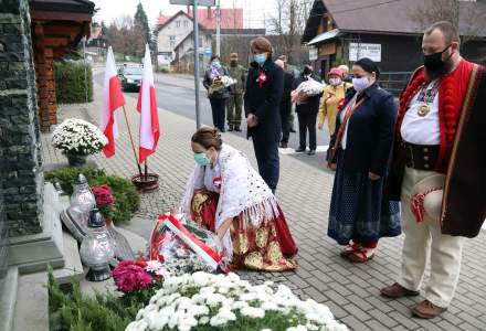 Wójt gminy Istebna Łucja Michałek składa wiązankę kwiatów pod pomnikiem pomordowanych w czasie II Wojny Światowej