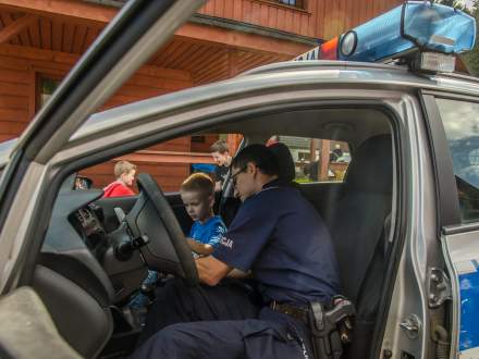 Policjant z dzieckim w samochodzie policyjnym