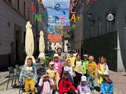 Dzieci na ulicy, gdzie rozwieszone są barwne litery