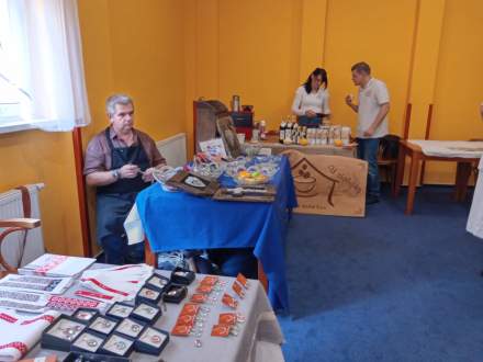 Róbert Hozák  i jego produkty z drutu, na planie pierwszym biżuteria z haftem, w tle ekspozycja kaw Vlasty Orešanská