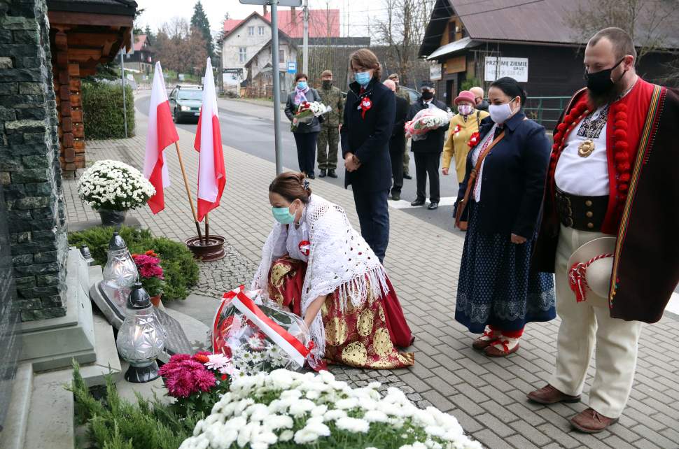 Wójt gminy Istebna Łucja Michałek składa wiązankę kwiatów pod pomnikiem pomordowanych w czasie II Wojny Światowej